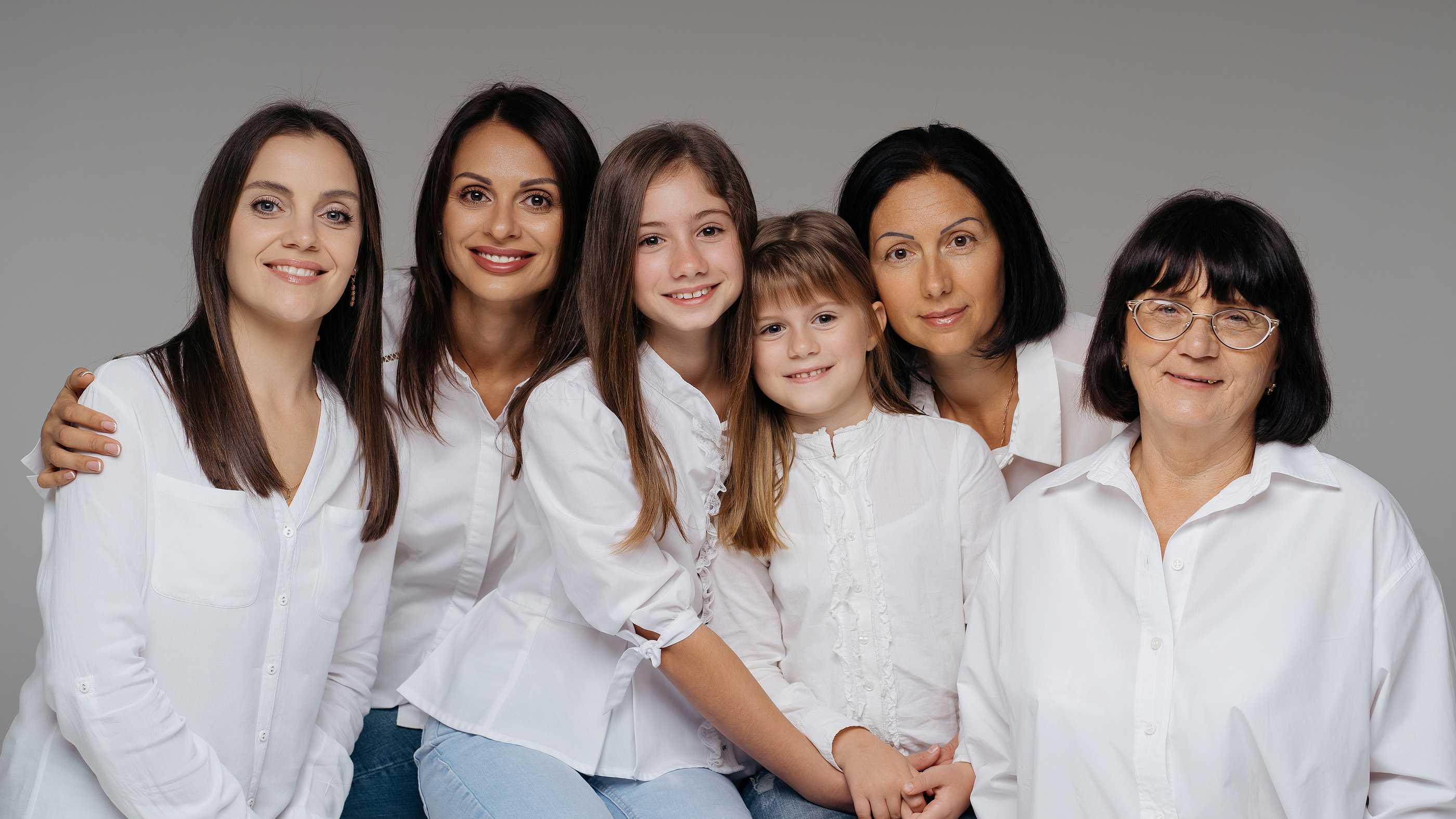 Six females of all ages wearing white shirts