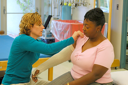 therapist wrapping arm of a patient with lymphedema