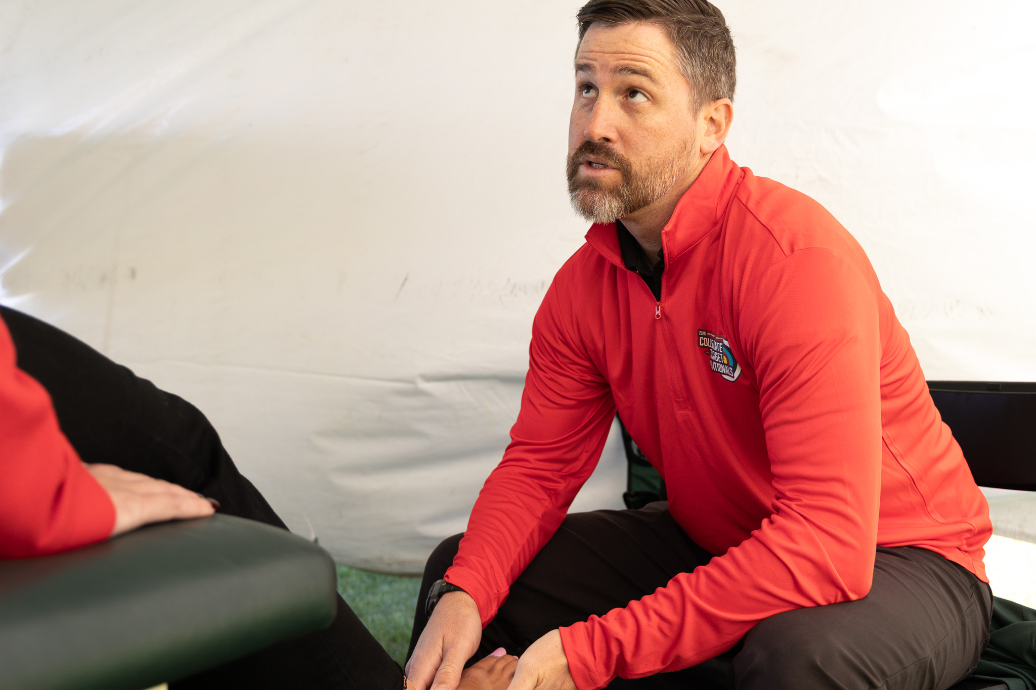 a sports medicine doctor evaluating an injury of a rugby player in clinic
