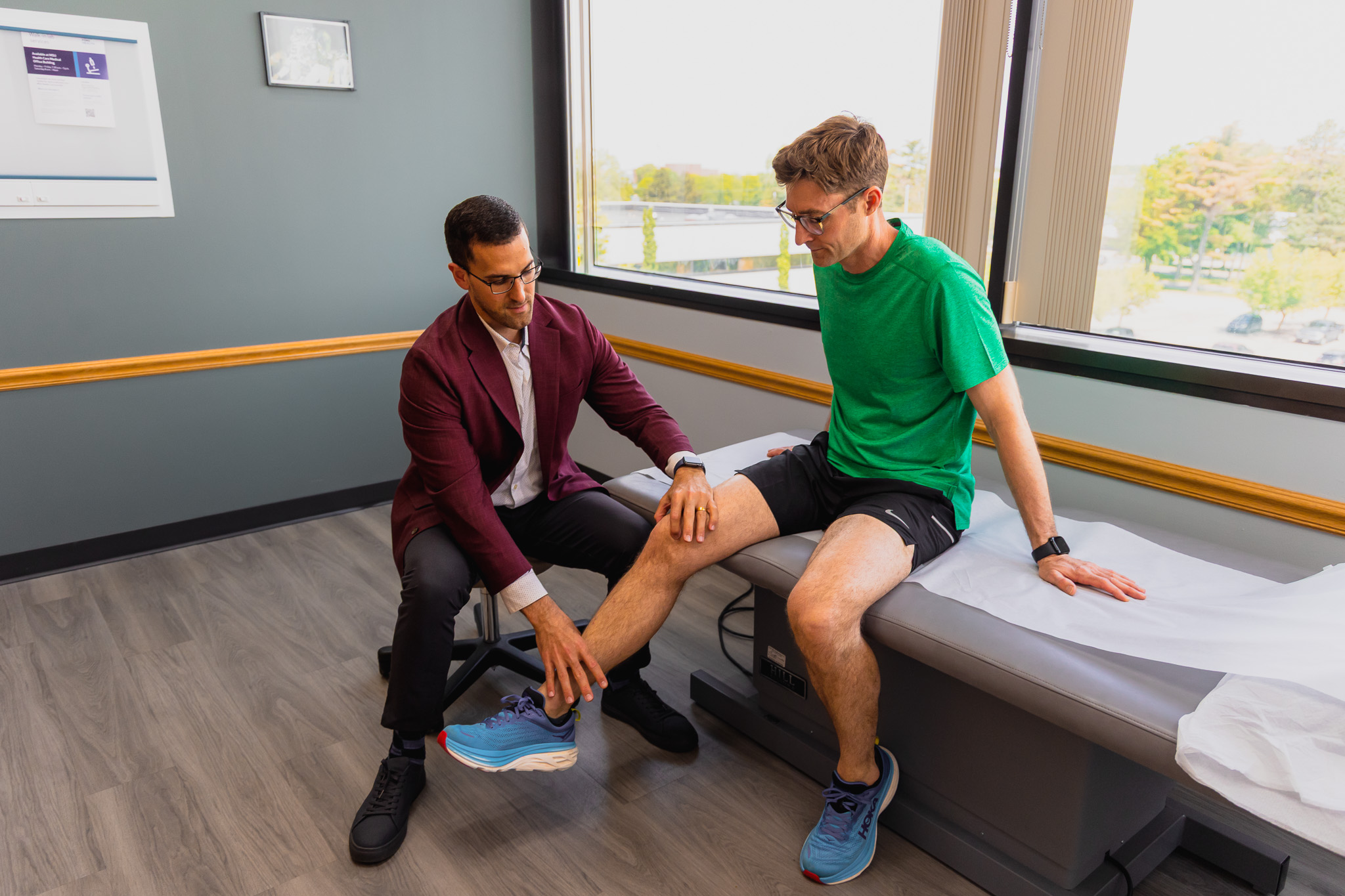 a sports medicine doctor evaluating an injury of a rugby player in clinic