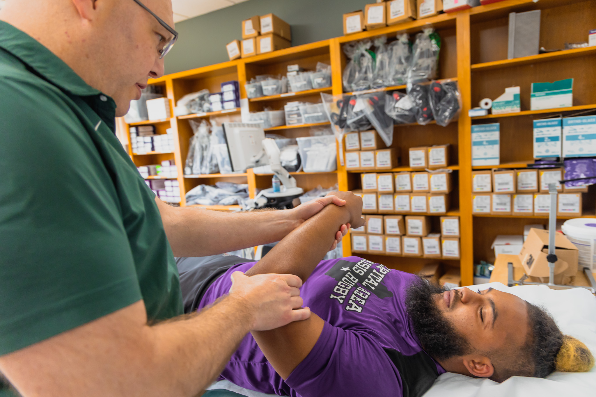a sports medicine doctor evaluating a patient in clinic